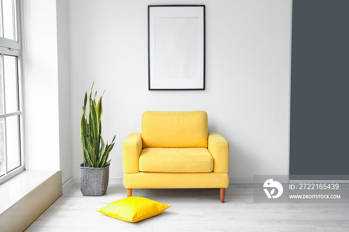 Interior of modern stylish room with armchair and blank photo frame