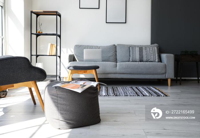 Textile pouf with magazine in interior of modern living room