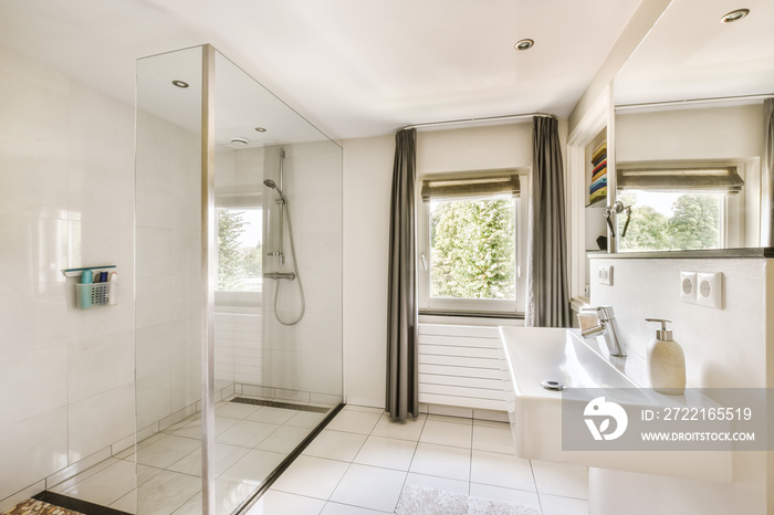 a modern bathroom with white tile flooring and large glass shower stall in the corner of the bathtub