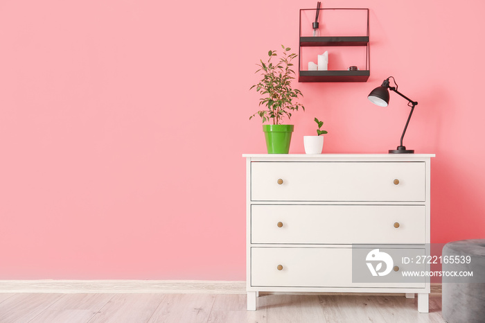 Modern chest of drawers near color wall in room