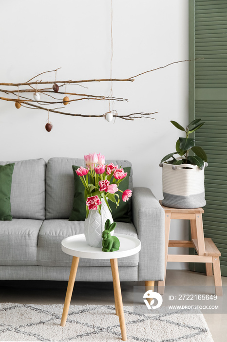 Stylish interior of living room with tulip flowers and Easter decor