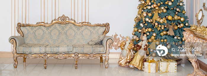 Beautiful decorated golden Christmas tree with present boxes in luxury classic interior.