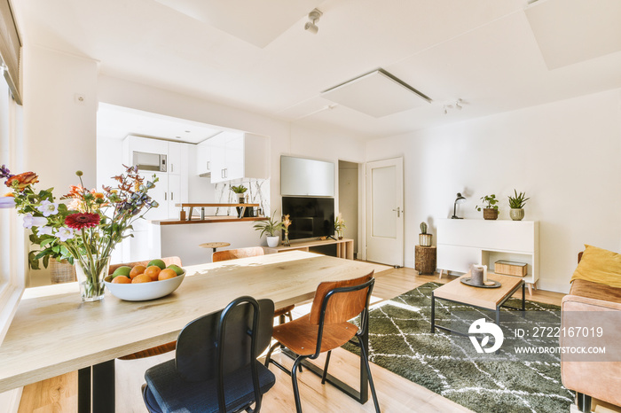 Contemporary minimalist style interior design of light studio apartment with wooden table and chairs