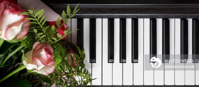 flat lay Closeup piano key on a wooden table with selective focus, and a bouquet of flowers, creativ