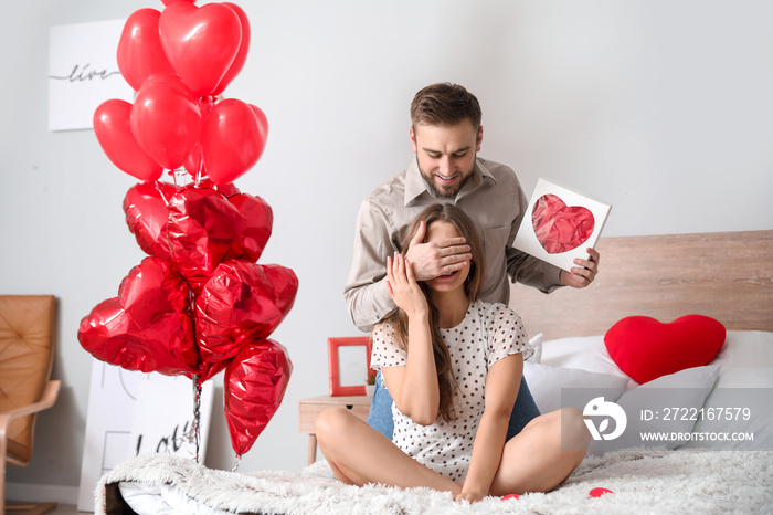 Happy young couple celebrating Valentines Day at home