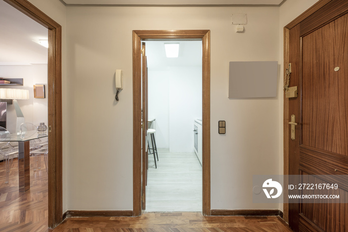 Distributor hall of a residential house with wooden floors, access to a fitted kitchen and a living 