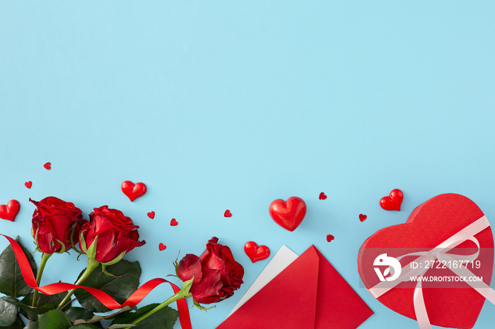 Valentines Day concept. Flat lay photo of red roses, hearts, envelope and heart shaped gift box on p