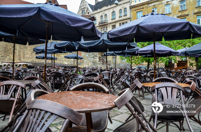 outdoor cafe with small round tables and wooden chairs table chair after rain at the cloudy day