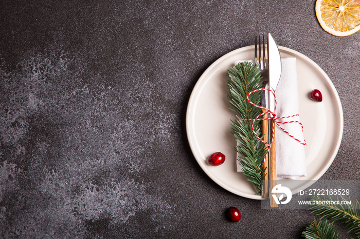 Christmas table with a plate, fork, knife, Christmas tree branches and Christmas decorations. top vi