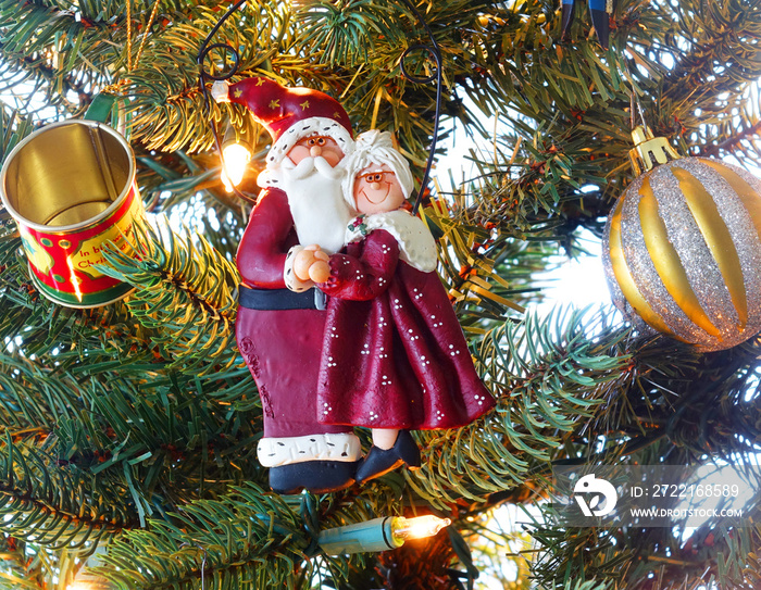 Santa and Mrs Claus hanging amongst the ornaments on a Christmas Tree