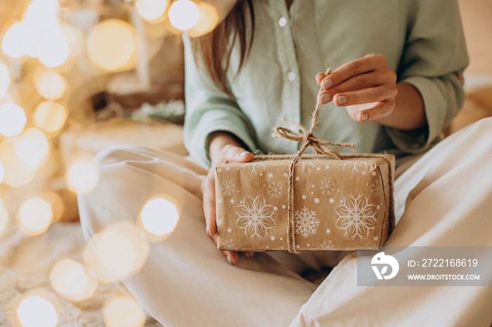 Woman holding christmas present close up photo