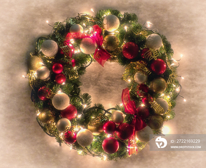 Lit Christmas wreath on white textured background
