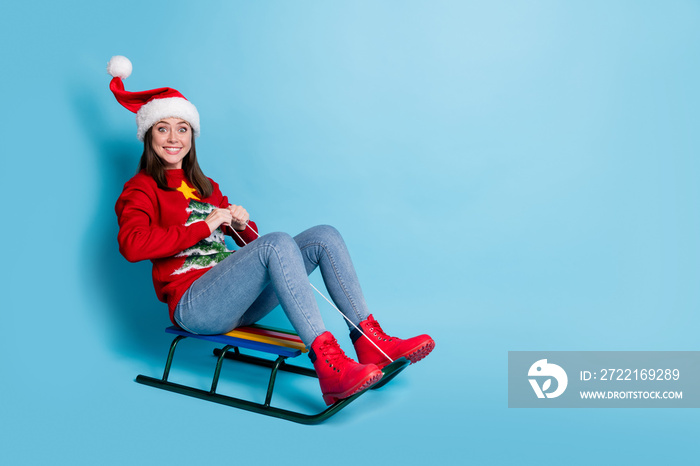 Photo portrait of woman riding sleigh into blank space isolated on pastel light blue colored backgro