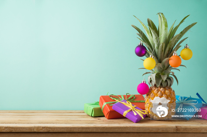 Christmas holiday concept with  pineapple as alternative Christmas tree and gift boxes