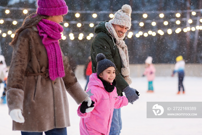 christmas, family and leisure concept - happy mother, father and daughter at outdoor skating rink in