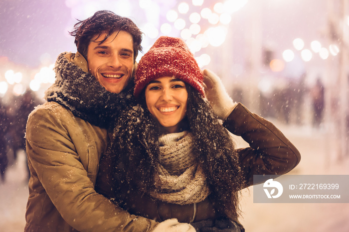 Couple Embracing Smiling At Camera Standing On Christmas Market