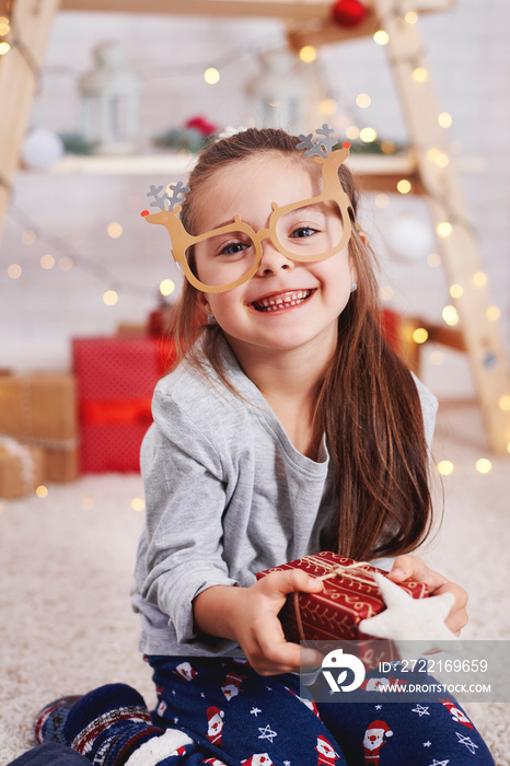 Portrait of cute girl holding christmas present