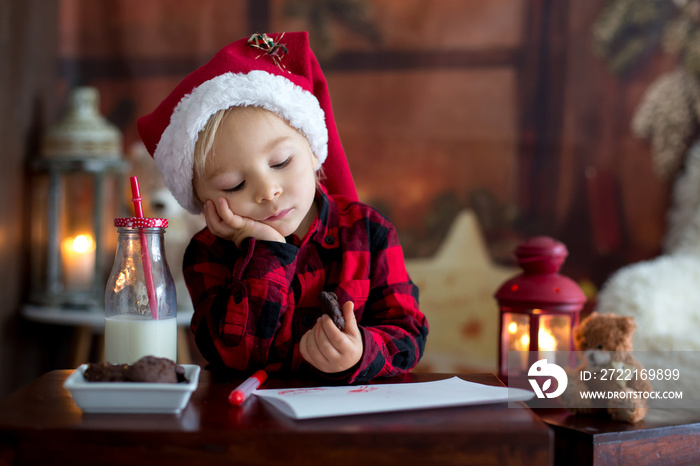 Sweet blonde toddler boy, writing letter to Santa, wishing present for the holidays