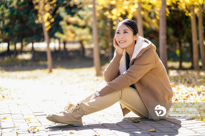 快乐的年轻女子托腮坐在路边