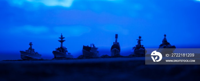 Military navy ships in a sea bay at sunset time. Selective focus