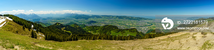 Aussicht von der Hohen Kugel über das Vorarlberger Rheintal mit Dörfern und Städten bis in die Schweiz mit Säntis, Alpstein und Churfirsten. Panorama im sonnigen Frühling mit kleinen Wolken am Himmel