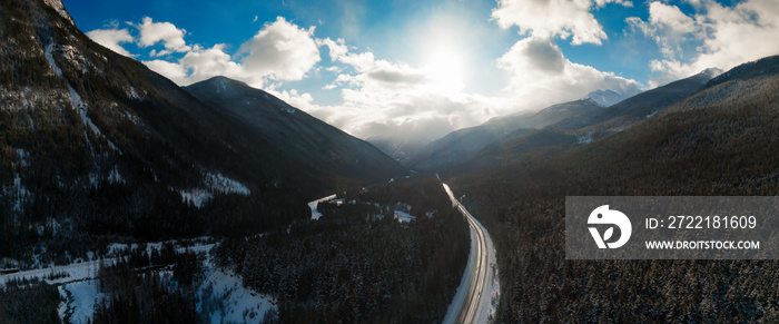 Aerial Panoramic View of a scenic Highway in the valley between Canadian Mountain Landscape during winter sunny sunset. Taken near Revelstoke, British Columbia, Canada.