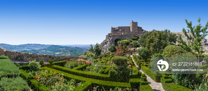 Marvao Castle on top of cliff with Alto Alentejo landscape in Portugal. Medieval Moorish fort or fortress and box hedge garden. Summer blue sky