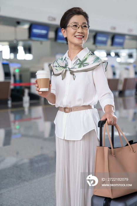 老年女人在机场拿着咖啡