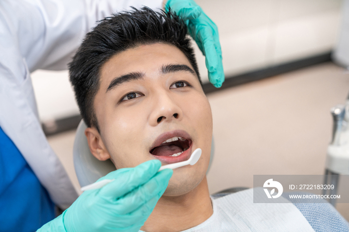 年轻男子在牙科诊所治疗牙齿