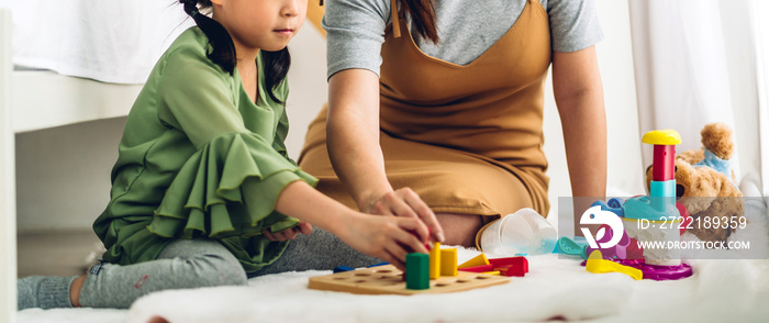 Portrait of enjoy happy asian little asian girl smiling playing with toy build wooden blocks board game at home