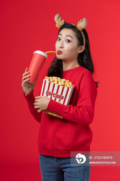 拿着爆米花和饮料的快乐女子