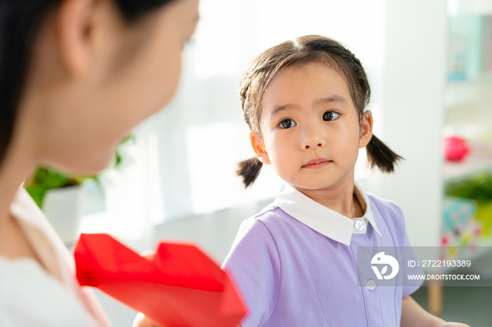 老师和小女孩一起折纸