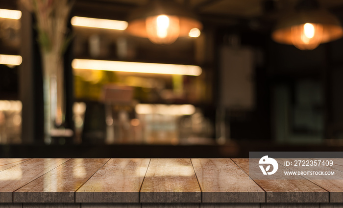 Empty wooden table top with lights bokeh on blur restaurant background.