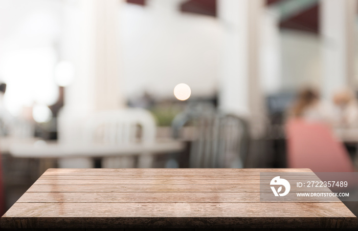 Empty wooden table top with lights bokeh on blur restaurant background.