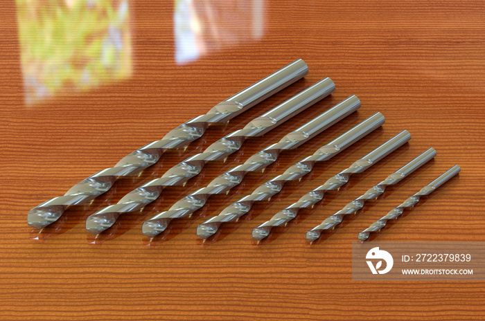 Set of drill bits on the wooden table. 3D rendering