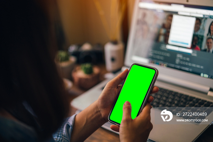 Woman holding a smartphone with green screen isolated on screen background.