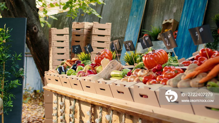 Local fresh produce at farmers market display stand with organic agricultural farming counter. Various colorful fresh seasonal fruits and vegetables lying on table at rural festival.