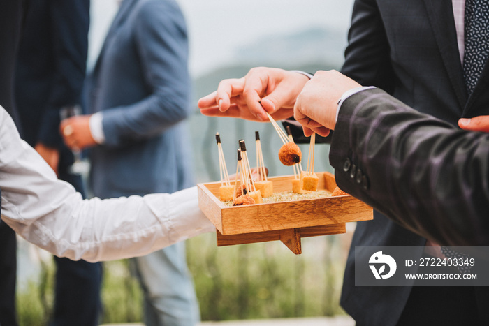 Male guests having appetizers at a party or wedding reception