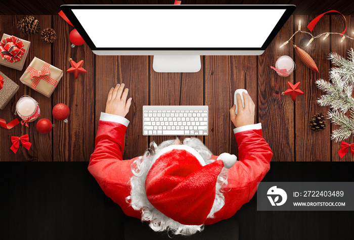 Christmas in Santa Claus home. Santa Claus use a computer to respond to letters from children around the world.