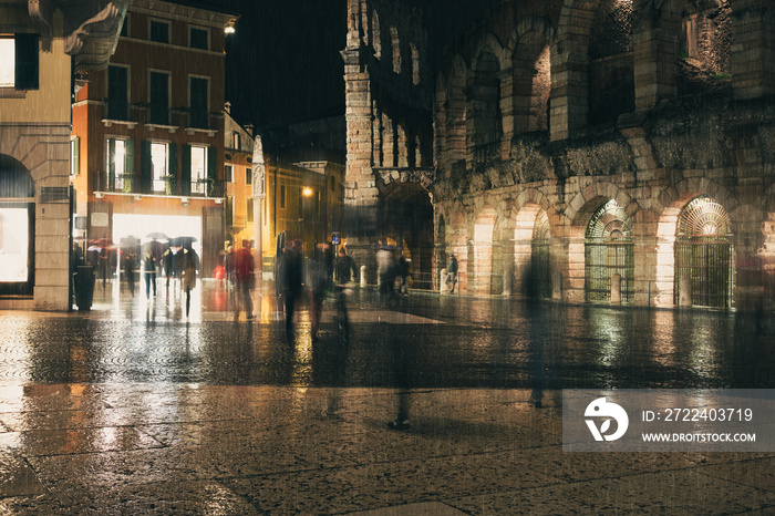 Old European night city lights and people walking blurred background