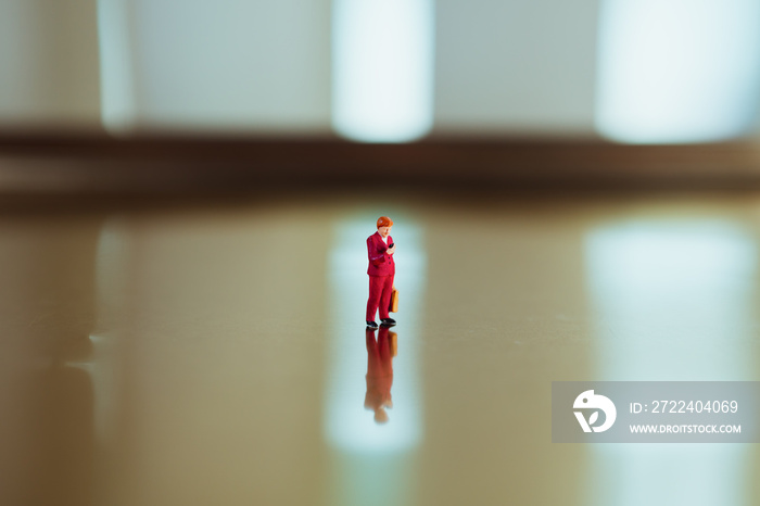 Miniature people, single woman standing alone using as business and communication concept