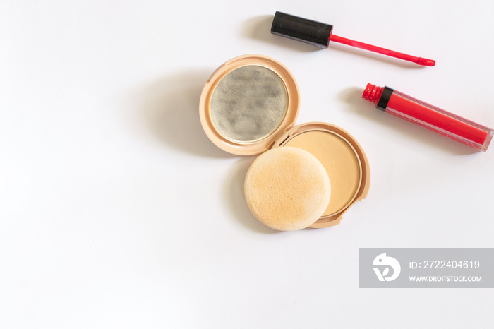 face powder with a mirror and red lipstick on a white background top view of makeup