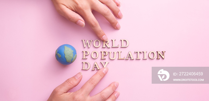 World population day write by wooden letter with globe and woman hands