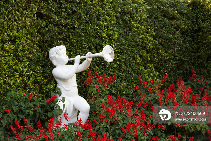 A white kid trumpeter statue in the garden