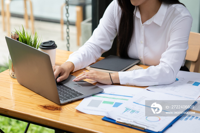 Close up of businesswoman working on desk office with using a calculator to calculate the numbers, finance accounting concept.