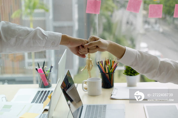 Businessman and businesswoman celebrating success in office.