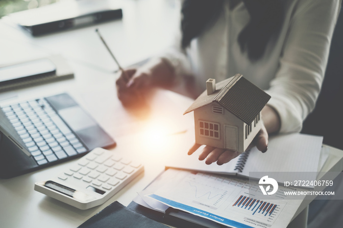 A woman holding and checking house model .Real Estate House Appraisal And Inspection and Insurance concept.