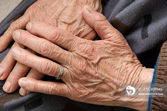 Covidien-19 virus and an elderly human hand,