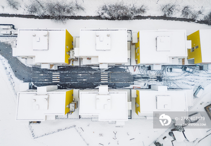 Top down view, snowy roof tops of modern apartment complex, directly above, newly built residential area