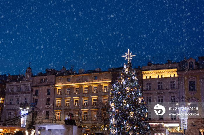 Large christmas tree illuminated at night standing on the Main Market Square in Krakow.